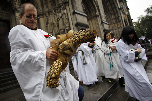 An animal handler picks up a tortoise after receiving a special blessing at the Cathedral of Saint John the Divine in New York