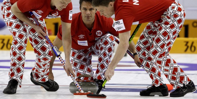 Norway skip Thomas Ulsrud delivers his stone as Loevold and Nergaard sweep during play against Sweden at the World Men's Curling Championship 2012 in Basel