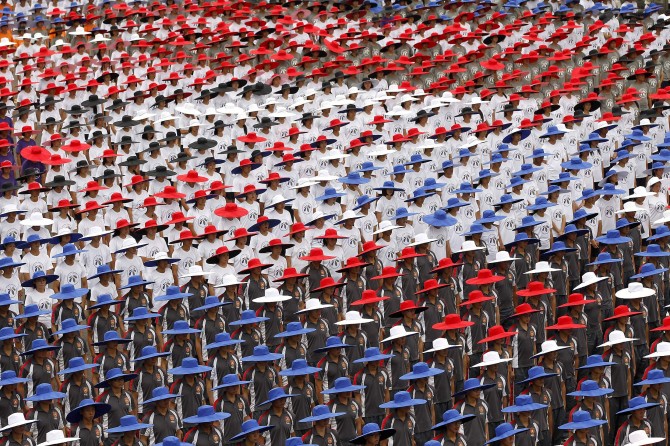 People wearing hats in the colours of Taiwan's national flag take part in the country's National Day celebrations in front of the presidential office in Taipei