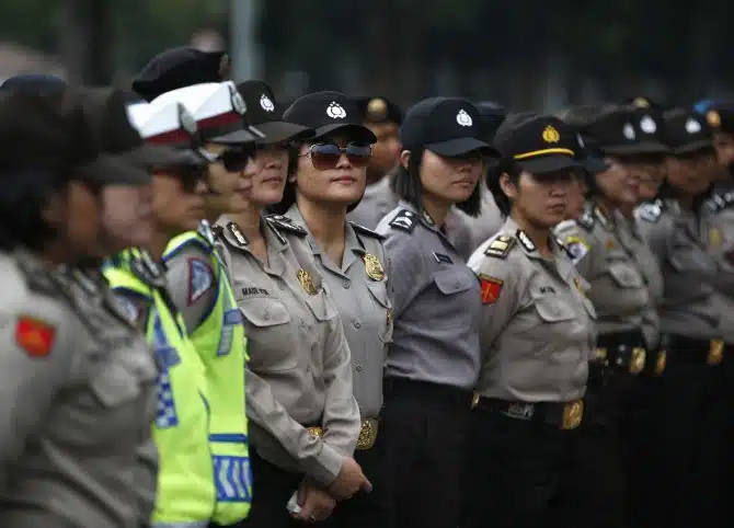 Indonesian police officers stand guard outside the presidential palace during a protest against the recent fuel price hike in Jakarta