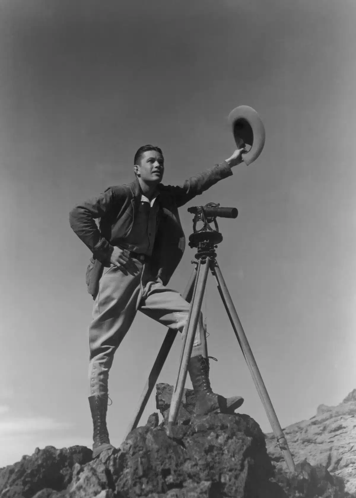 ca. 1931-1936, Boulder City, Nevada, USA --- A surveyor waves his cowboy hat as a signal to fellow workers at Boulder Dam. Now called Hoover Dam, it is one of the world's largest dams, holding back the waters of the Colorado River between Arizona and Nevada to create power and Lake Mead. Nevada. --- Image by © CORBIS