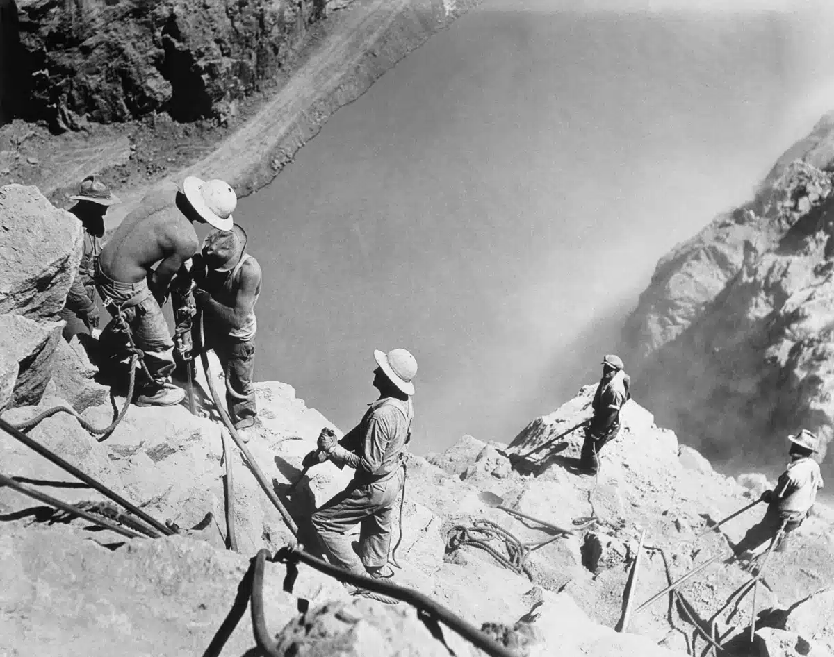 ca. 1935, Boulder City, Nevada, USA --- Shaving the walls of Black Canyon, 550 feet above the mighty Boulder Dam. --- Image by © Bettmann/Corbis