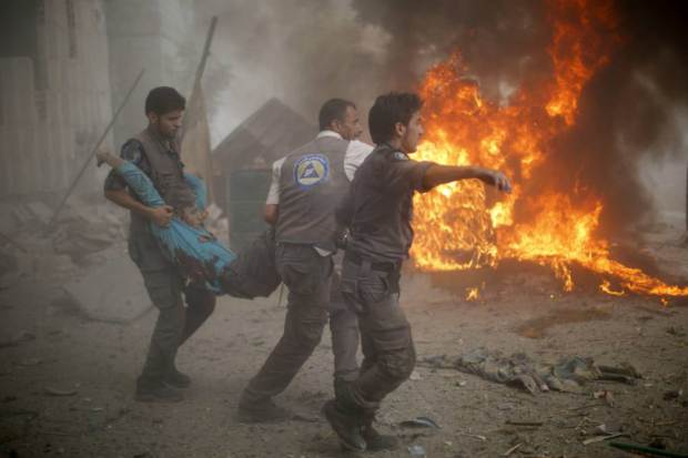 Syrian emergency personnel carry a wounded man following air strikes by Syrian government forces on a marketplace in the rebel-held area of Douma, east of the capital Damascus, on August 16, 2015. At least 70 people were killed and 200 people were injured, with the death toll -most of them civilians- likely to rise as many of the wounded were in serious condition, the Syrian Observatory for Human Rights said. AFP PHOTO / SAMEER AL-DOUMYSAMEER AL-DOUMY/AFP/Getty Images