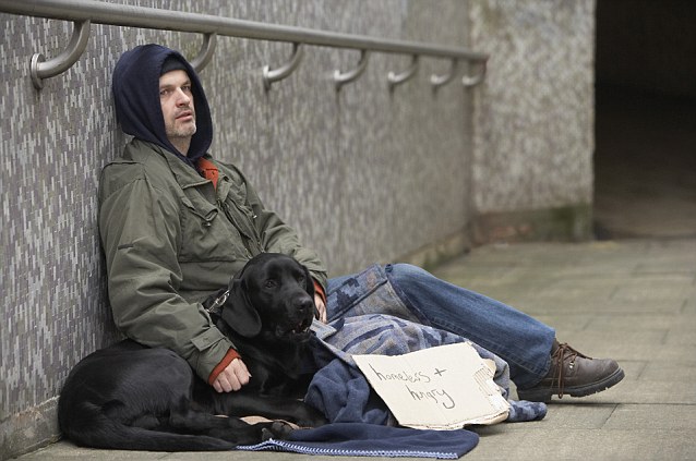 Homeless man with dog and sign