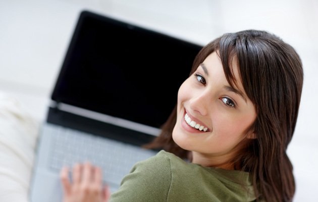 Portrait of a happy young female using a laptop