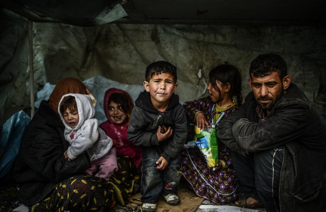A Syrian refugee family from Aleppo, stay under a shelter during a rainy day on March 8, 2014, at Uskudar in Istanbul. More than 136,000 people have been killed in Syria's brutal war since March 2011, and millions more have fled their homes. AFP PHOTO/BULENT KILIC (Photo credit should read BULENT KILIC/AFP/Getty Images)