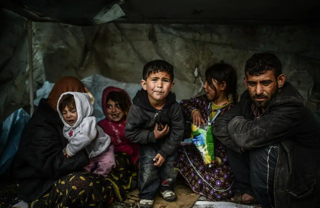 A Syrian refugee family from Aleppo, stay under a shelter during a rainy day on March 8, 2014, at Uskudar in Istanbul. More than 136,000 people have been killed in Syria's brutal war since March 2011, and millions more have fled their homes. AFP PHOTO/BULENT KILIC (Photo credit should read BULENT KILIC/AFP/Getty Images)