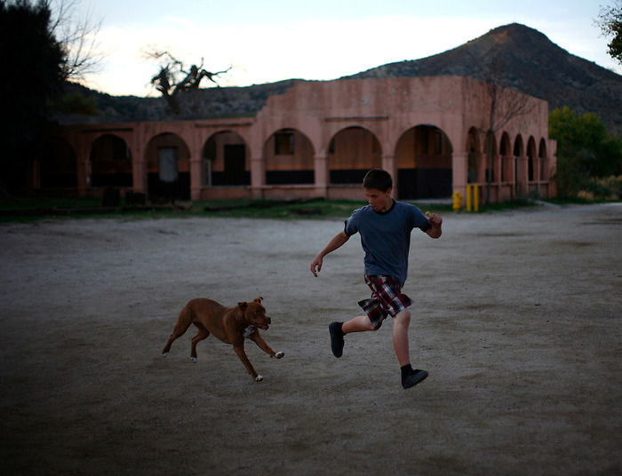 A dog chases a boy in Jacumba, California November 7, 2010. Jacumba is a small border town of less than 1,000 people known mainly for its hot springs. The town, located about a half a mile from the border in unincorporated San Diego county, does not have a port of entry into Mexico, though residents say there is significant illegal immigrant and drug traffic through the town.