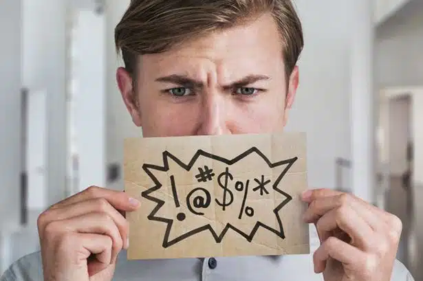 man-holding-swear-word-sign-in-front-of-his-mouth