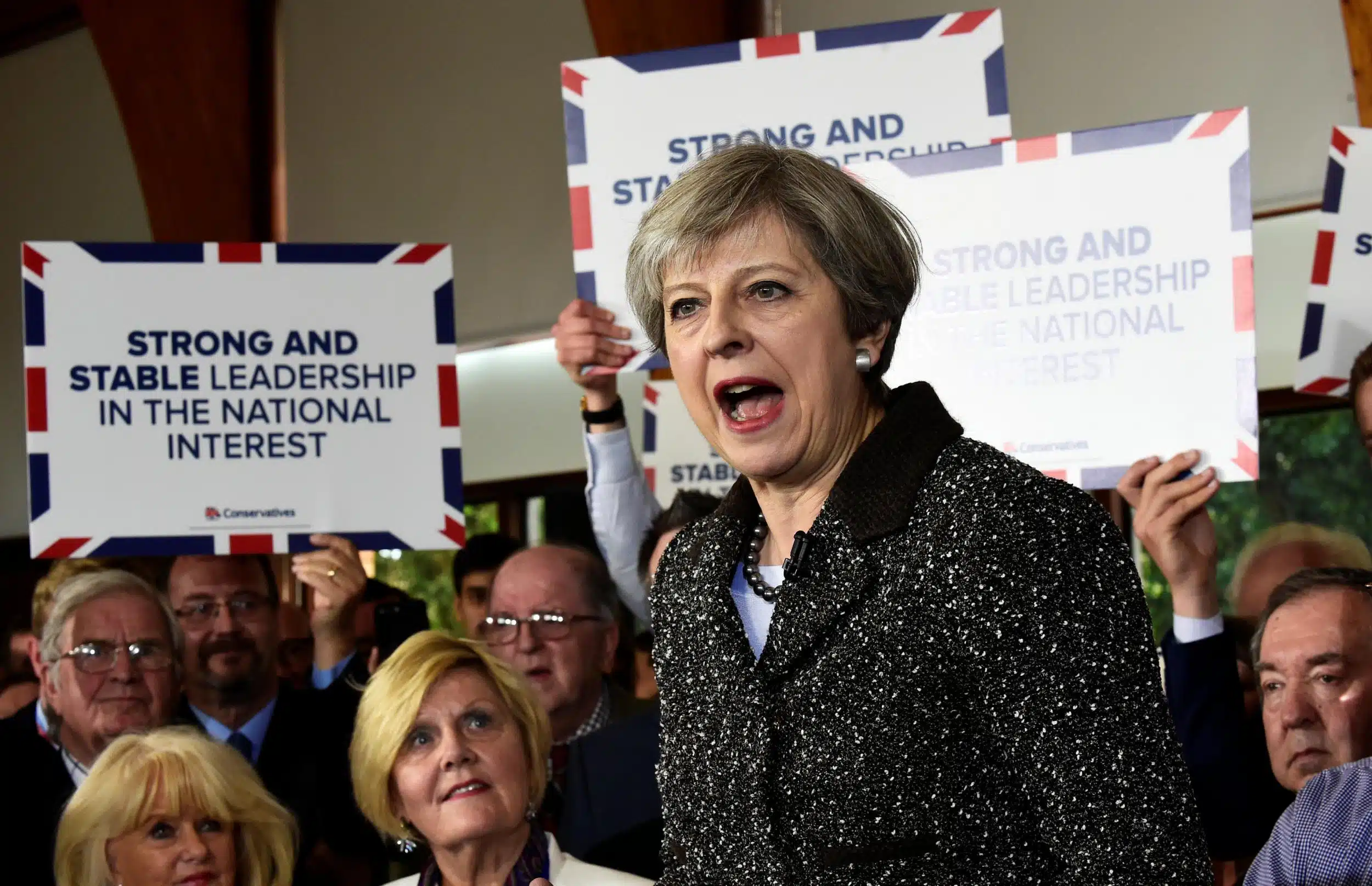 theresa-may in front of slogan