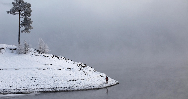 A fisherman stands on the frozen bank of the Yenisei River near Russia's Siberian