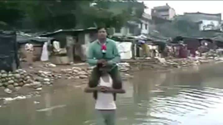 Indian News Reporter Narayan Pargaien Uses Flood Victim To Keep Himself Dry While Reporting