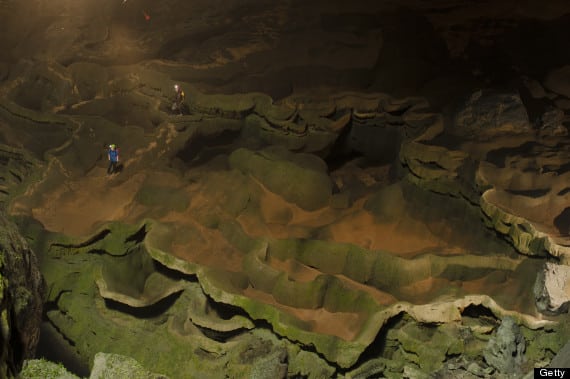 Hang Son Doong explorers navigate an algae-covered cavescape.