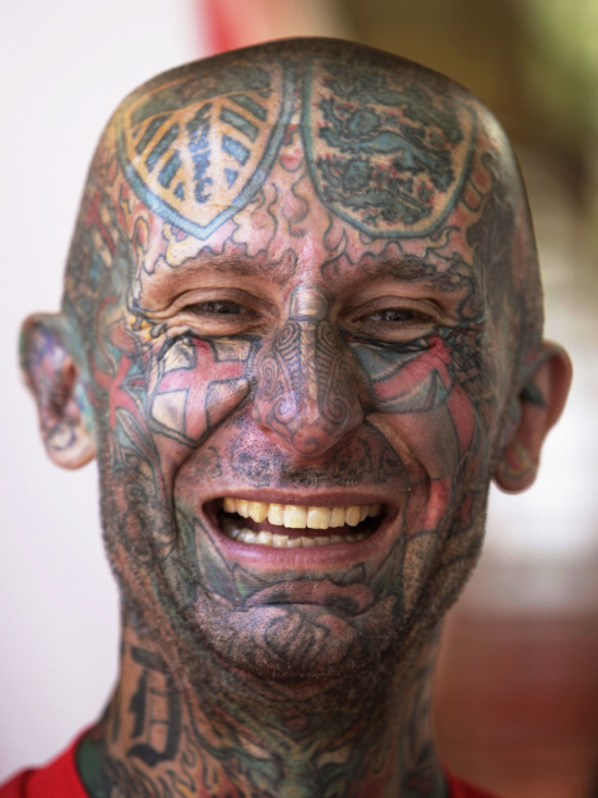 British soccer fan with tattoed face smiles as he parties in the centre of Donetsk