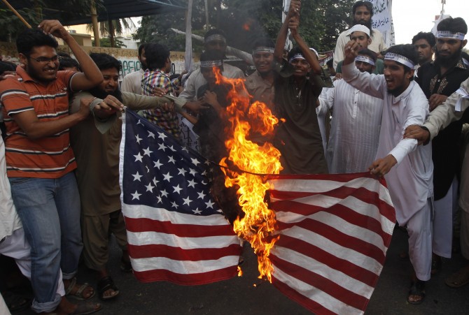 Supporters of the Jamaat-ud-Dawa Islamic organization burn the U.S. flag as they shout slogans during a protest, against U.S. drone attacks in the Pakistani tribal region, in Karachi