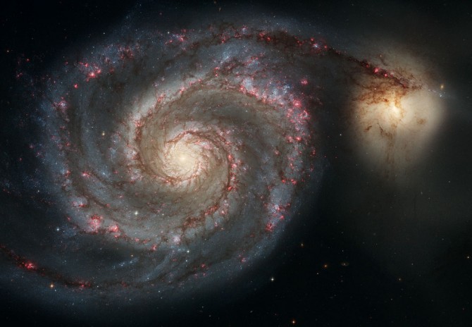 Amazing Space -  small galaxy passing behind a bigger spiral one