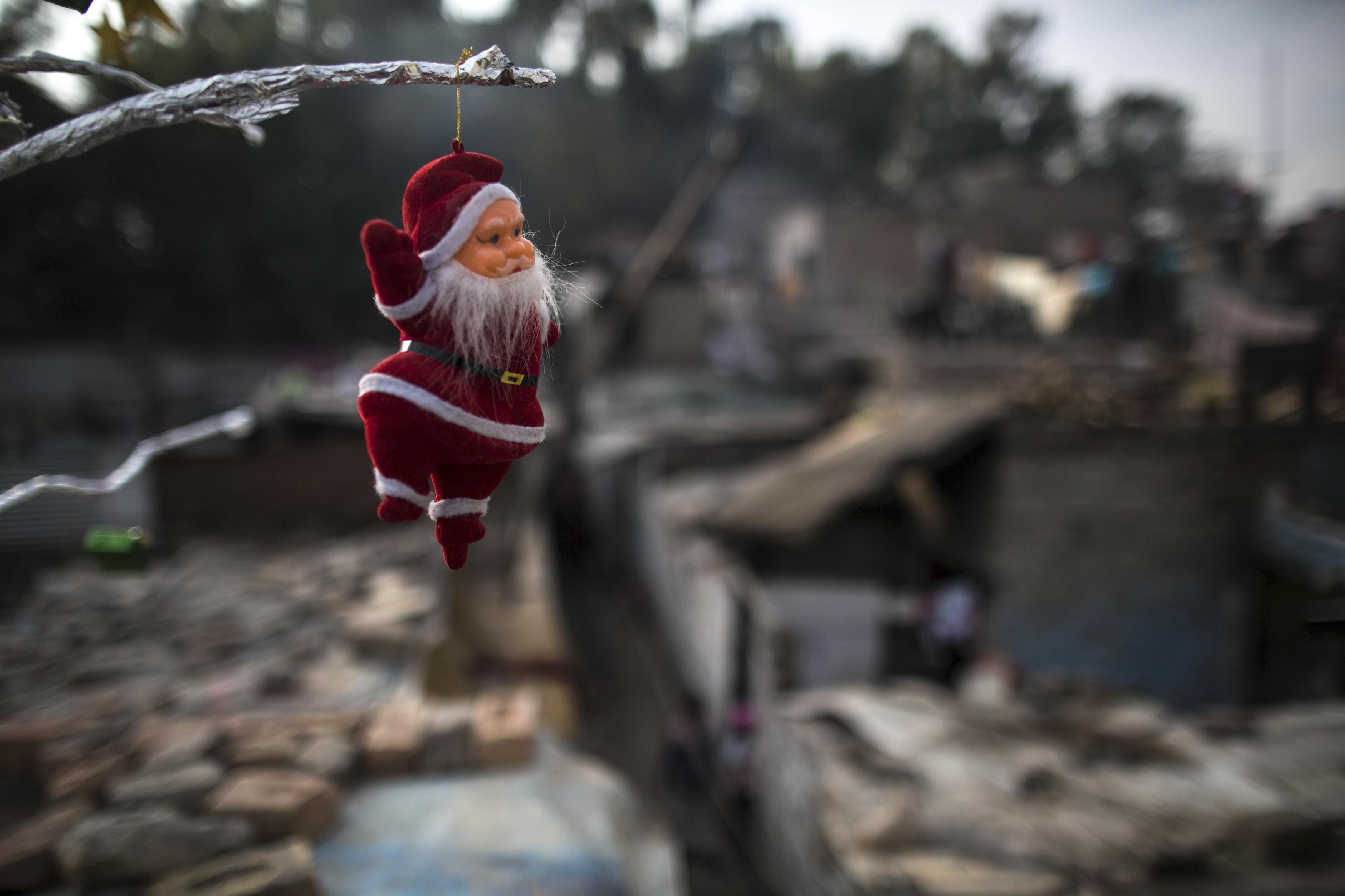 A Santa Claus figurine hangs from a tree ahead of Christmas in a Christian slum in Islamabad