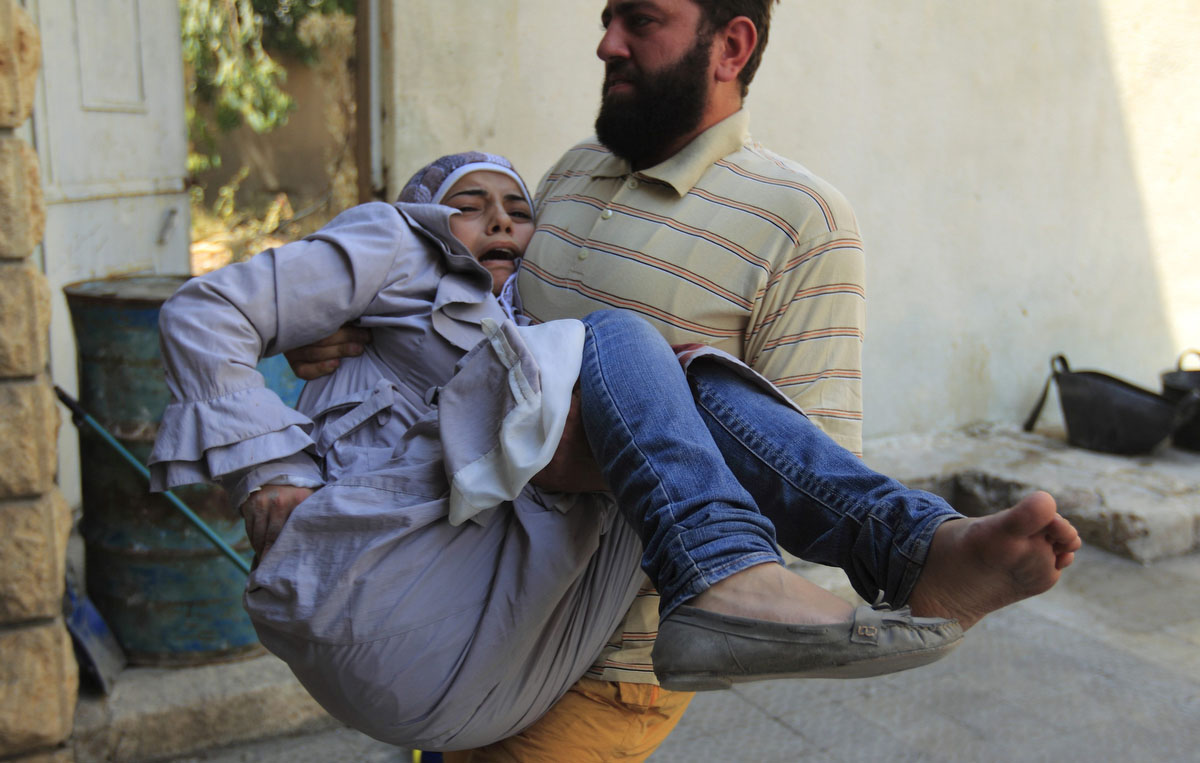 A member of the Free Syrian Army carries an injured civilian after shelling by forces loyal to President Bashar Al-Assad in Aleppo