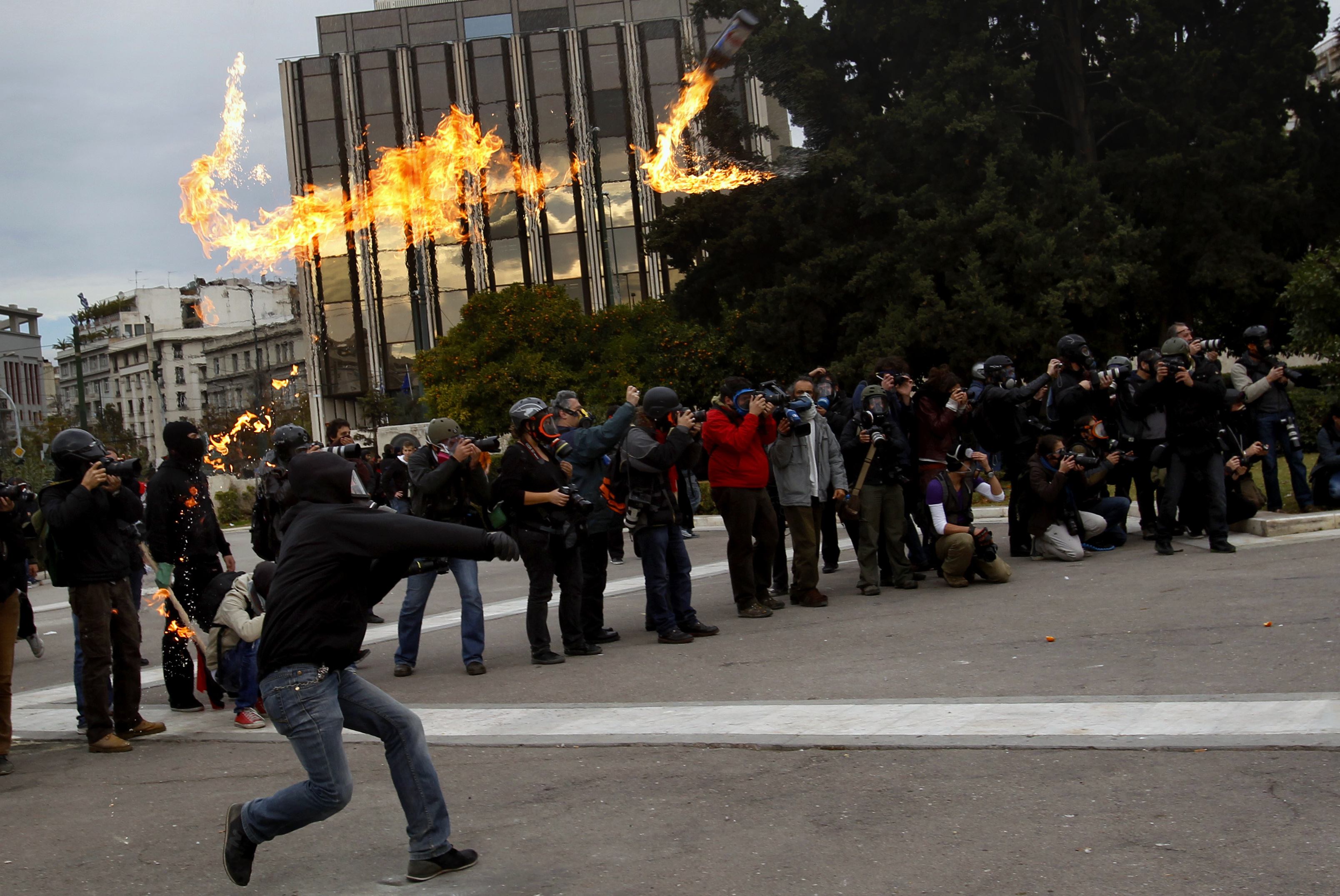 A masked youth throws a petrol bomb at police in Athens' Syntagma (Constitution) square during clashes