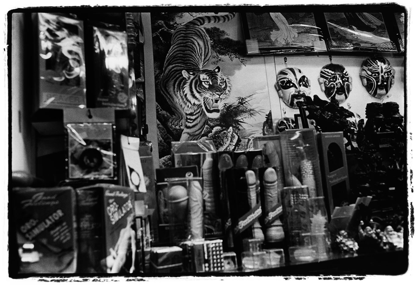 ChinaHong KongSex toys and Chinese masks for sale in a shop on a Hong Kong market. The image of the tiger in the background is a symbol of strength and fertility. 2008