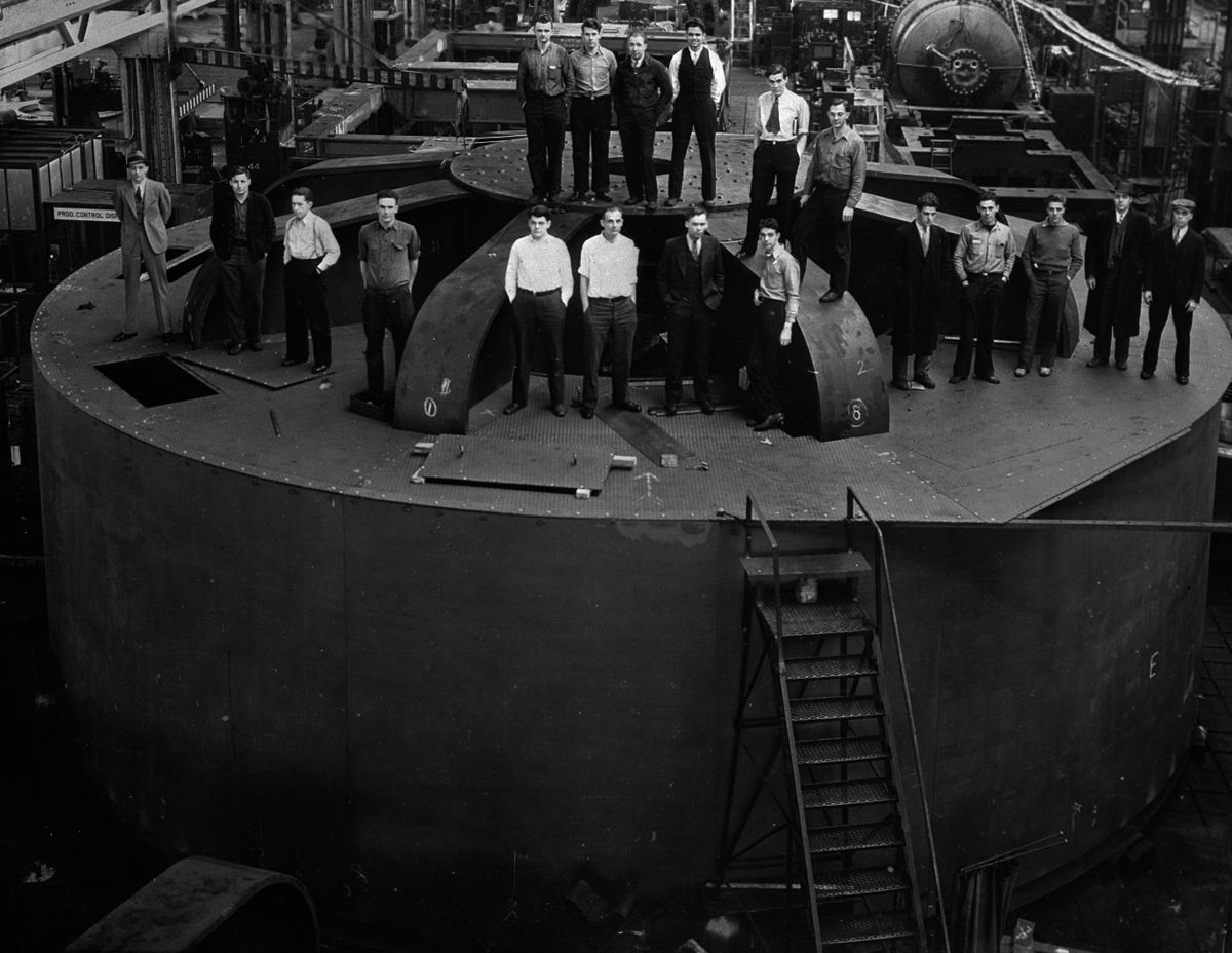 30 Jan 1935 --- Original caption: First of the gigantic hydroelectric generators for Boulder dam. The 19 student engineers representing 15 different universities at the Schenectady works of the general electric company, where the 82,500 KVA. unit was built, are shown atop the world's largest". Weighing two million pounds, the generator must be taken apart and shipped to Black Canyonj on 45 freight cars. --- Image by © Bettmann/CORBIS