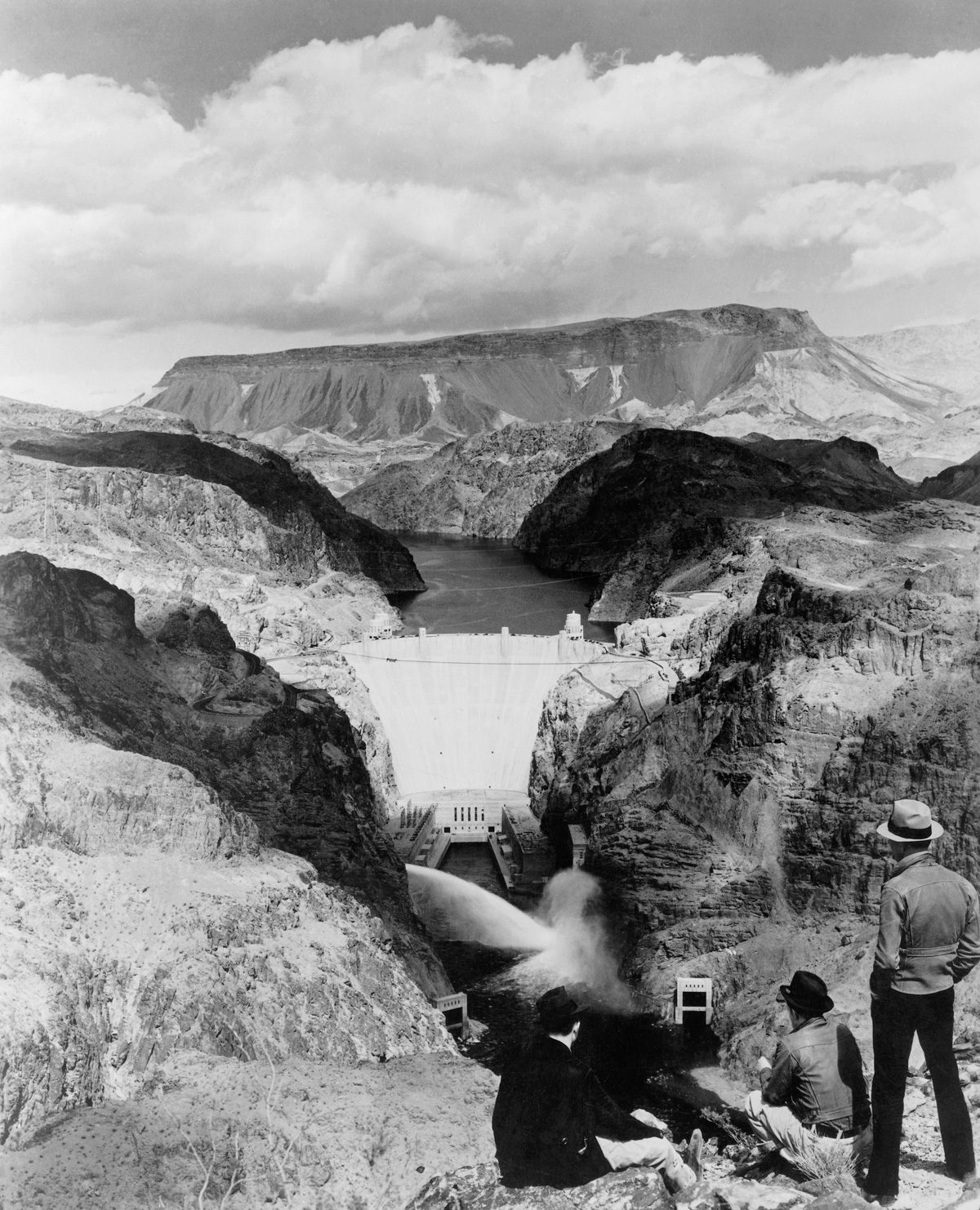 1940, Arizona, USA --- Men take in the view of the Boulder Dam and Lake Mead from the Nevada side of the Colorado River. | Location: Border of Arizona and Colorado, USA. --- Image by © Schenectady Museum; Hall of Electrical History Foundation/CORBIS