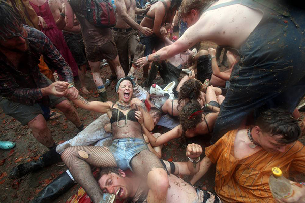 GLASTONBURY, ENGLAND - JUNE 30: People take part in a tomato fight at the Common at the Glastonbury Festival of Contemporary Performing Arts site at Worthy Farm, Pilton on June 30, 2013 near Glastonbury, England. Gates opened on Wednesday at the Somerset dairy farm that will be playing host to one of the largest music festivals in the world and this year features headline acts Artic Monkeys, Mumford and Sons and the Rolling Stones. Tickets to the event which is now in its 43rd year sold out in minutes and that was before any of the headline acts had been confirmed. The festival, which started in 1970 when several hundred hippies paid 1 GBP to watch Marc Bolan, now attracts more than 175,000 people over five days. (Photo by Matt Cardy/Getty Images)