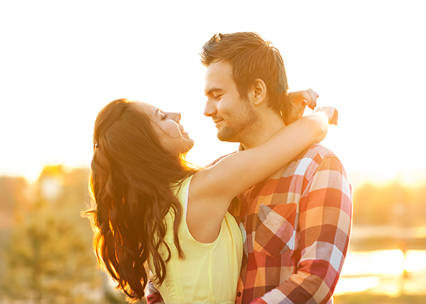 Young couple in love walking in the park near the river.