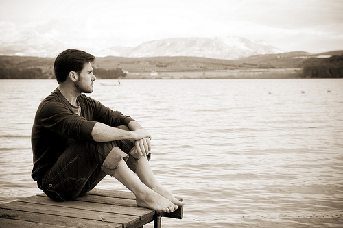 Young pensive man in nature background.