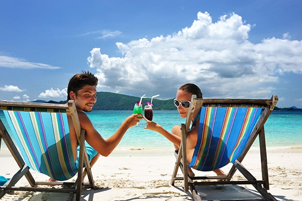 Couple on a tropical beach in chaise lounge