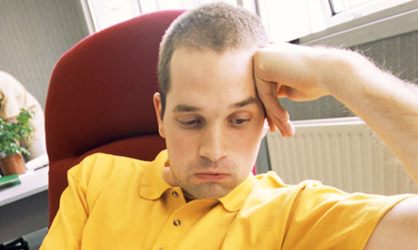 Man sitting at desk looking bored