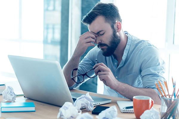 Feeling exhausted. Frustrated young beard man massaging his nose