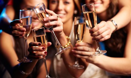 Group of partying girls clinking flutes with sparkling wine