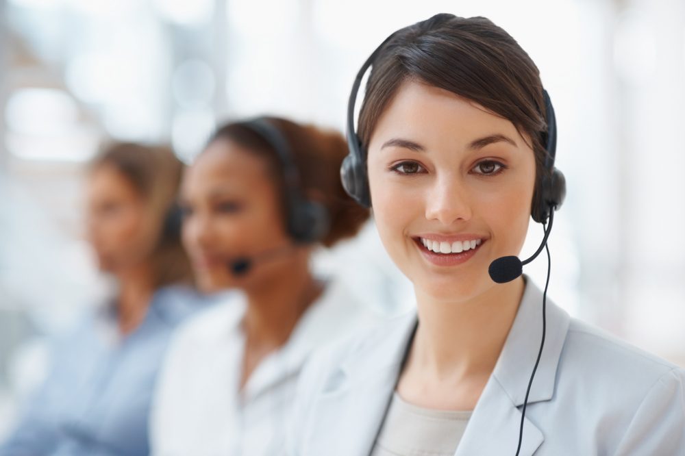 Closeup of a call center employee with headset at workplace