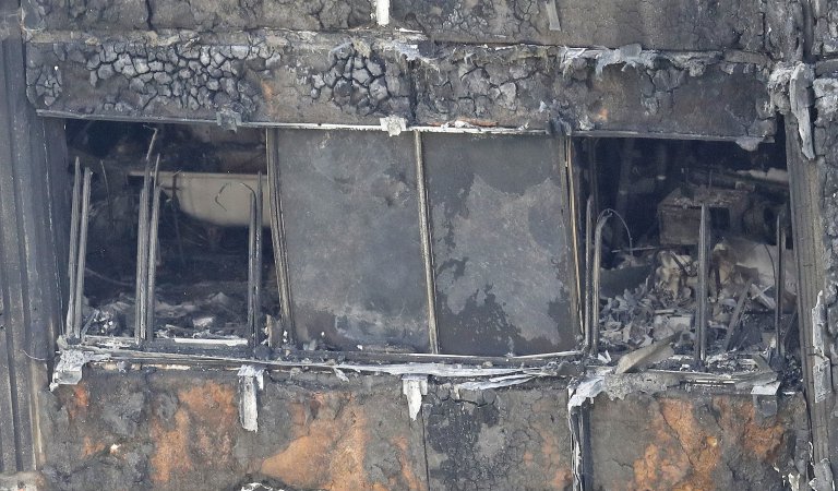 Part of the scorched facade of the Grenfell Tower in London as firefighting continue to damp-down the deadly fire, Thursday, June 15, 2017. A massive fire raced through the 24-storey high-rise apartment building in west London early Wednesday, and London fire commissioner says it will take weeks for the building to be searched and 'cleared'. (AP Photo/Frank Augstein)