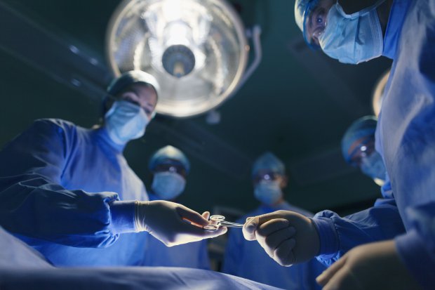 Operating room staff performing hospital surgery