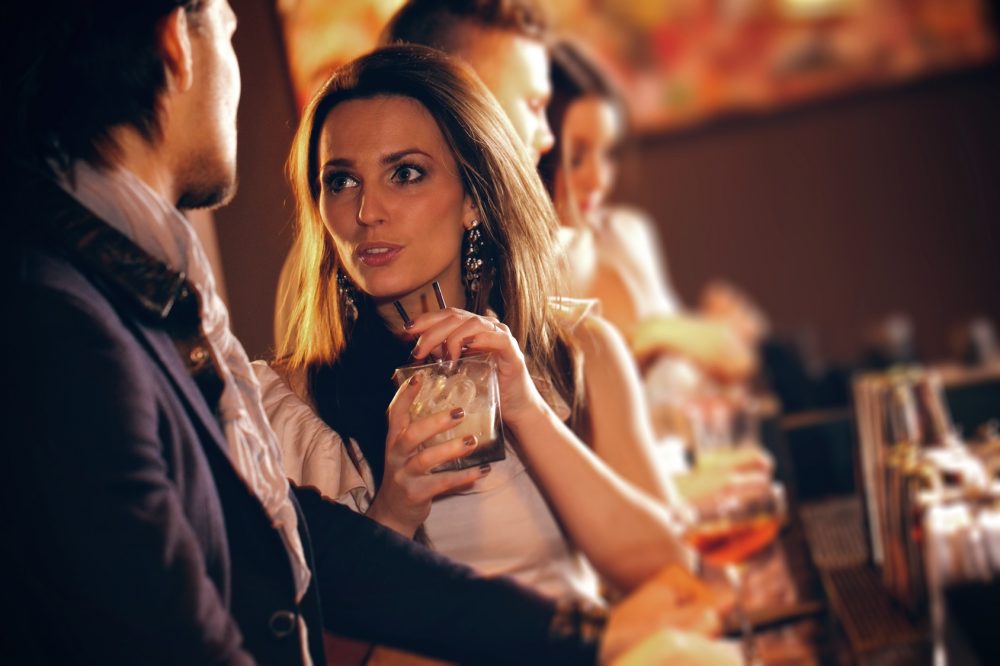 Young Woman in Conversation with a Guy at the Bar