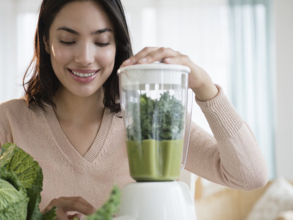 Hispanic woman blending healthy smoothieHispanic woman blending healthy smoothie