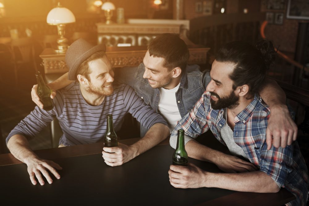 happy male friends drinking beer at bar or pub