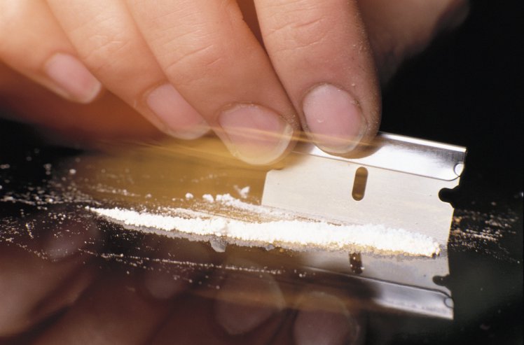 Cutting Line of Cocaine with Razor Blade