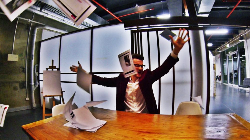 Business man throwing paperwork in frustration
