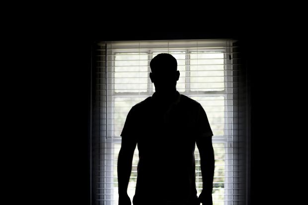 Silhouette of a man by a window