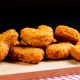Close-Up Of Chicken Nuggets On Cutting Board Against Black Background